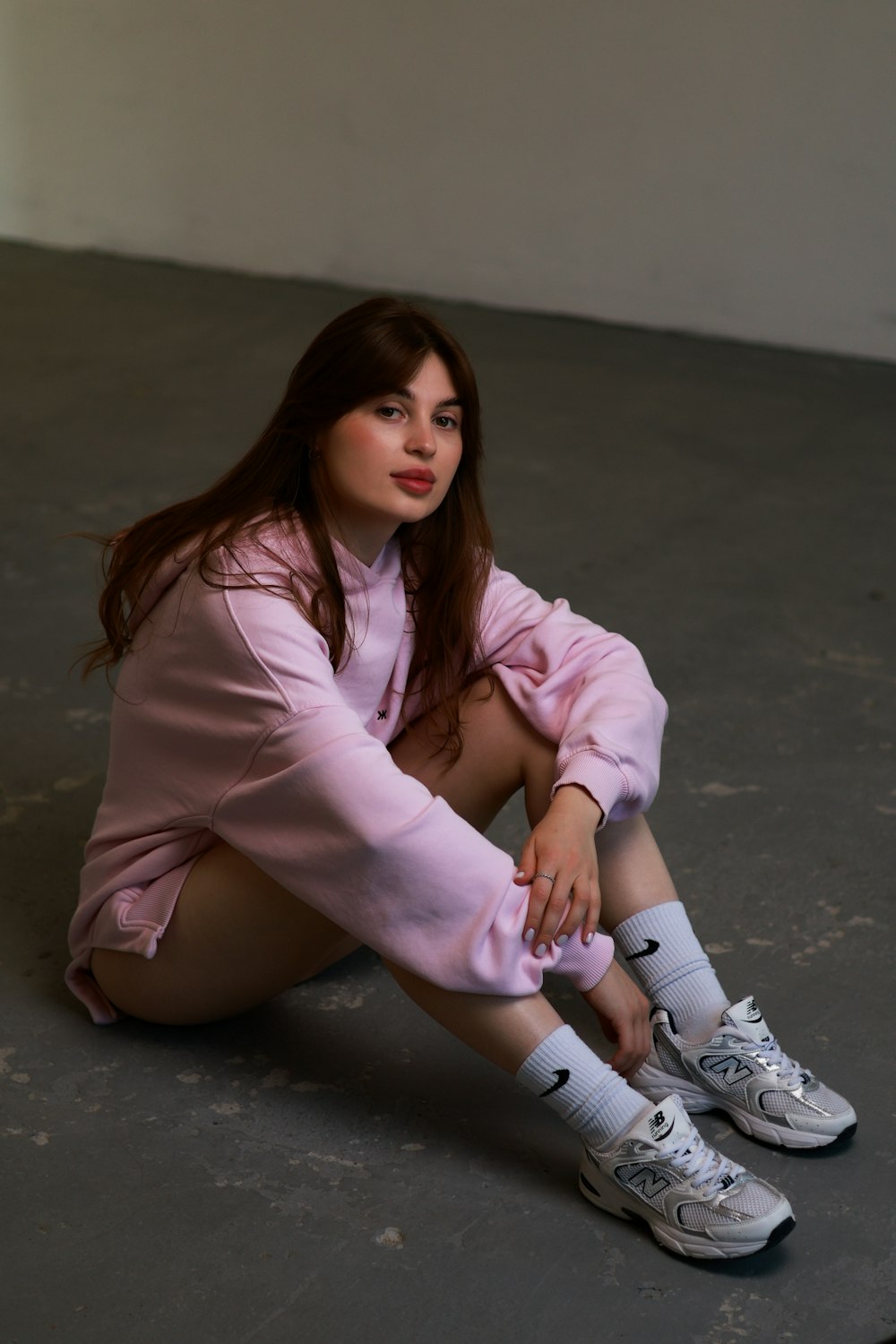 a woman sitting on the ground with her legs crossed