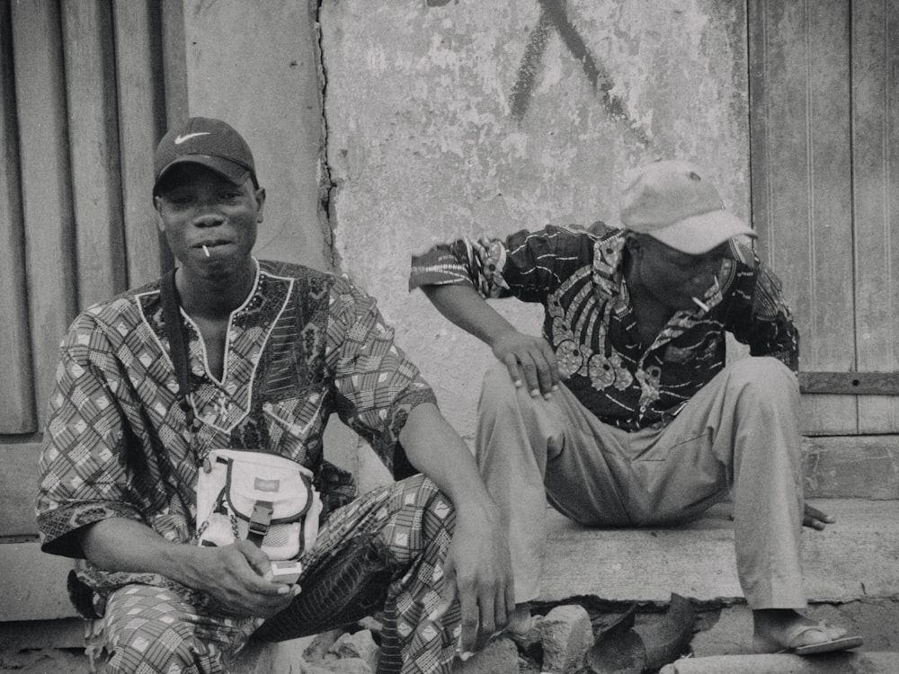 a couple of men sitting next to each other