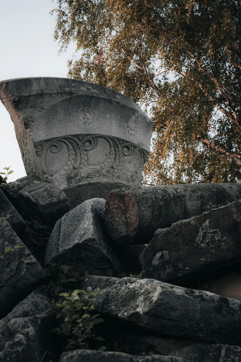 a large cement pot sitting on top of a pile of rocks