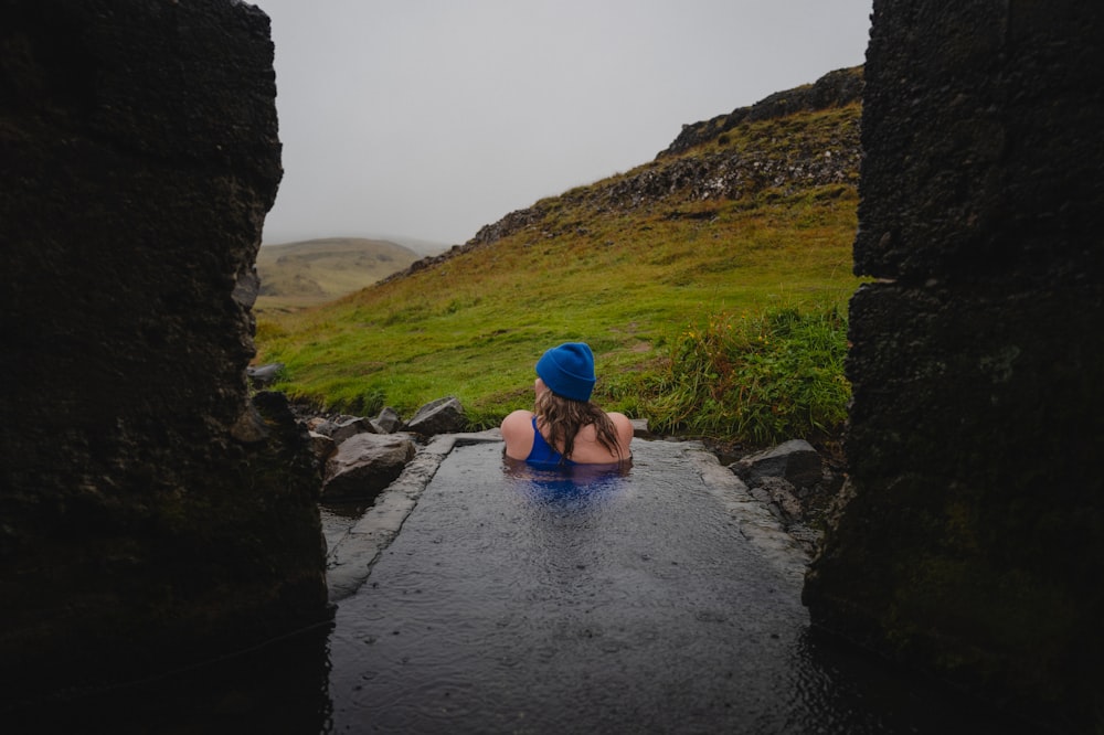 a woman in a blue hat sitting in a hot tub