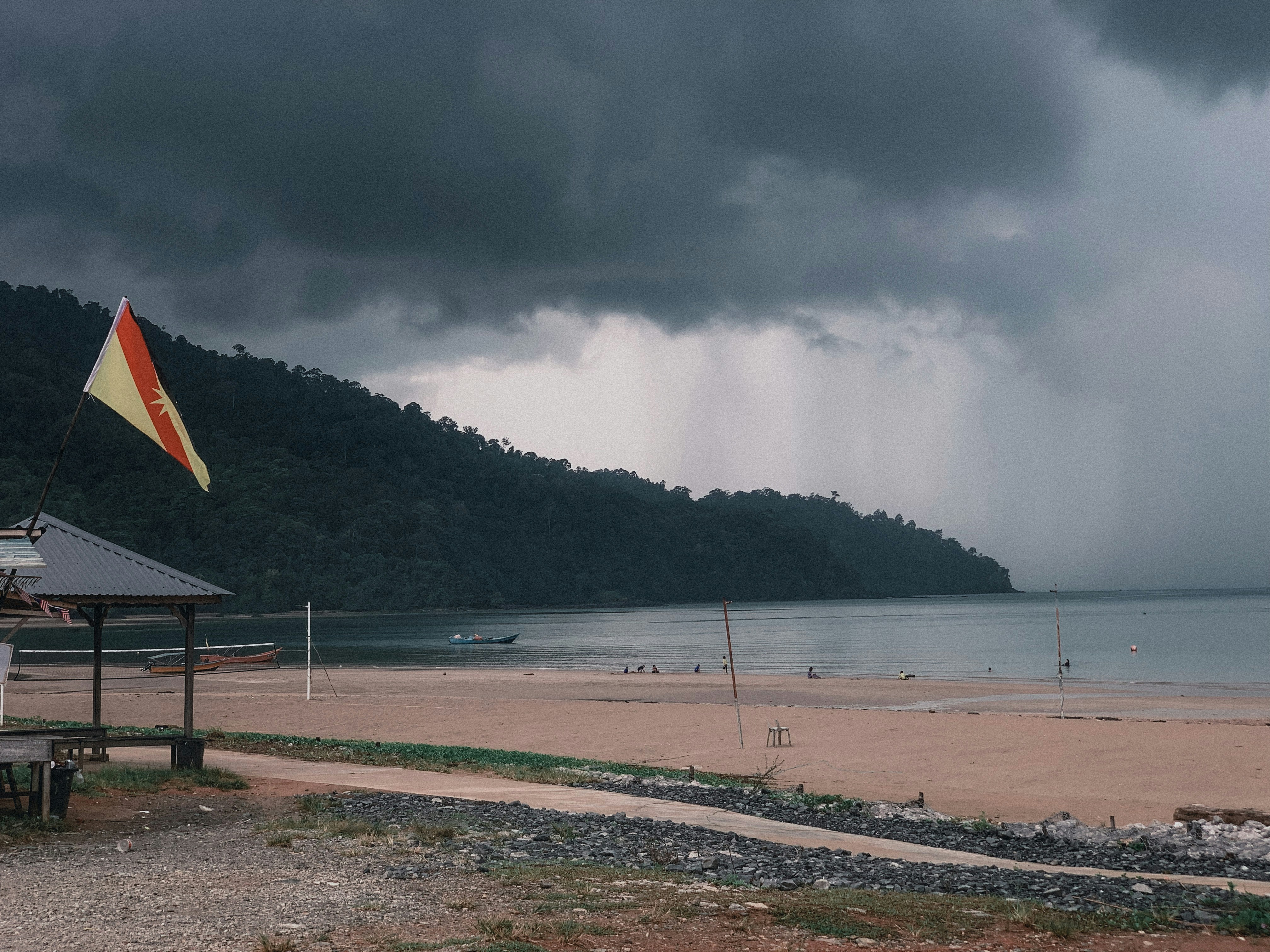 Un día nublado en una playa con un bote en el agua