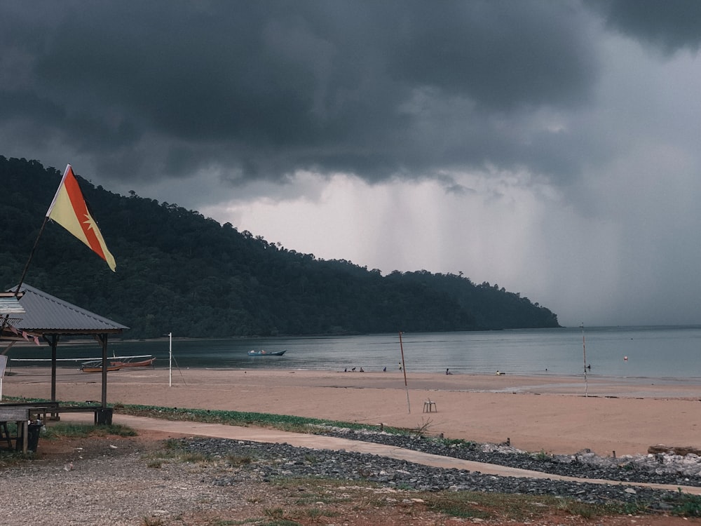 a cloudy day at a beach with a boat in the water