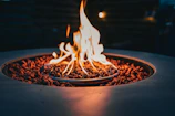 Close-up of a traditional volcanic stone cooking pit glowing softly with embers.