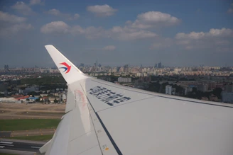 A sleek aircraft cruising above Chicago’s skyline blending into Bangalore’s tech park landscape.