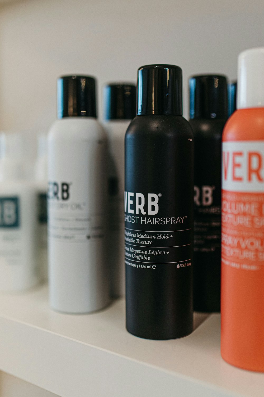 a white shelf topped with lots of different types of hair products