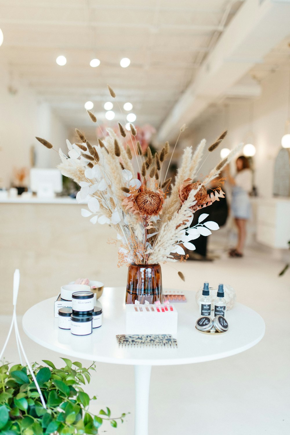 a white table topped with a vase filled with flowers