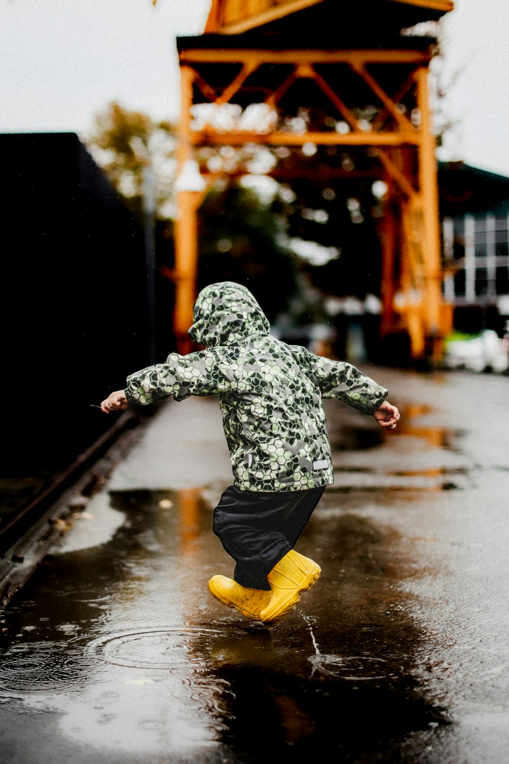 ein kleines Kind, das im Regen in die Luft springt