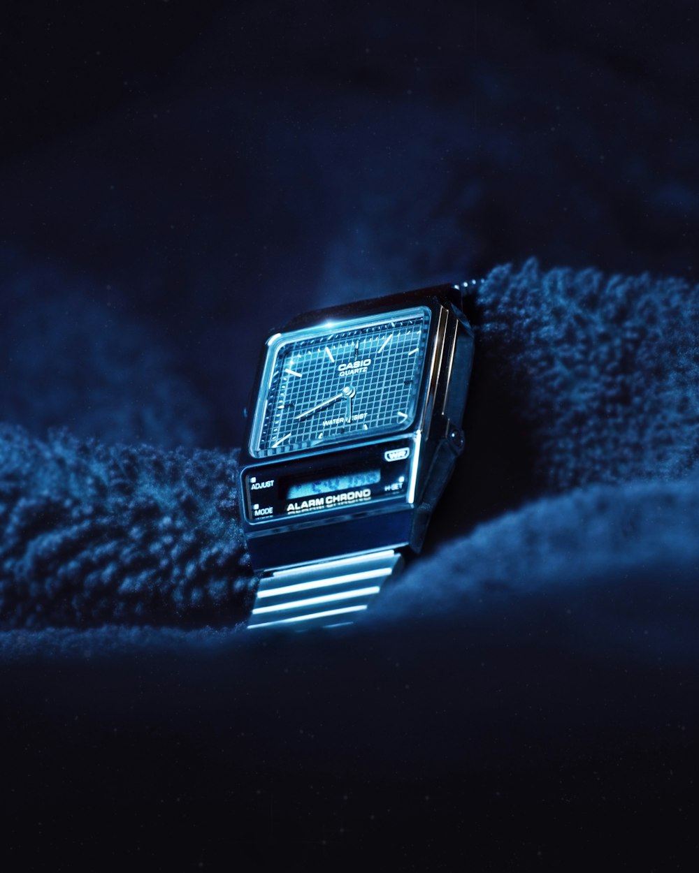 a watch sitting on top of a blue blanket