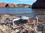 A drone conducting an inspection of a coastal structure.