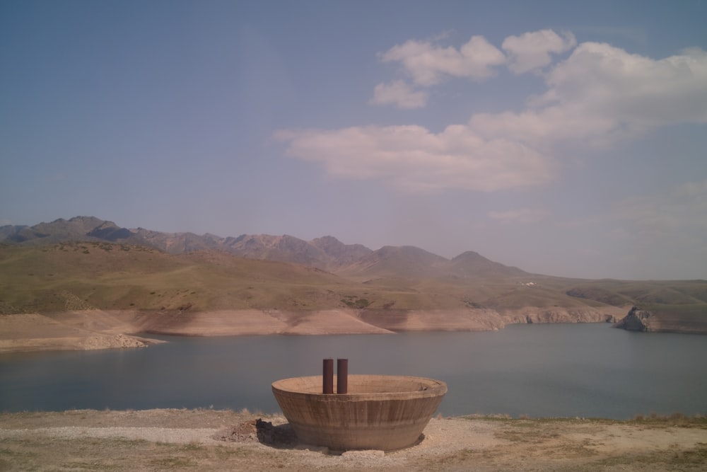 a large wooden bowl sitting on top of a dirt field