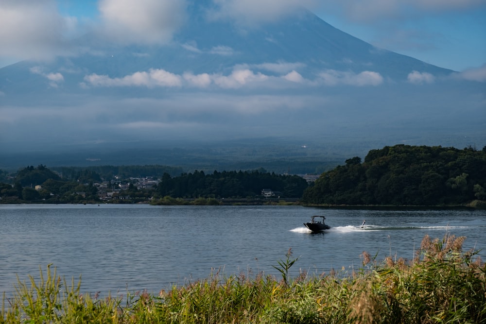 a boat in the water with a mountain in the background