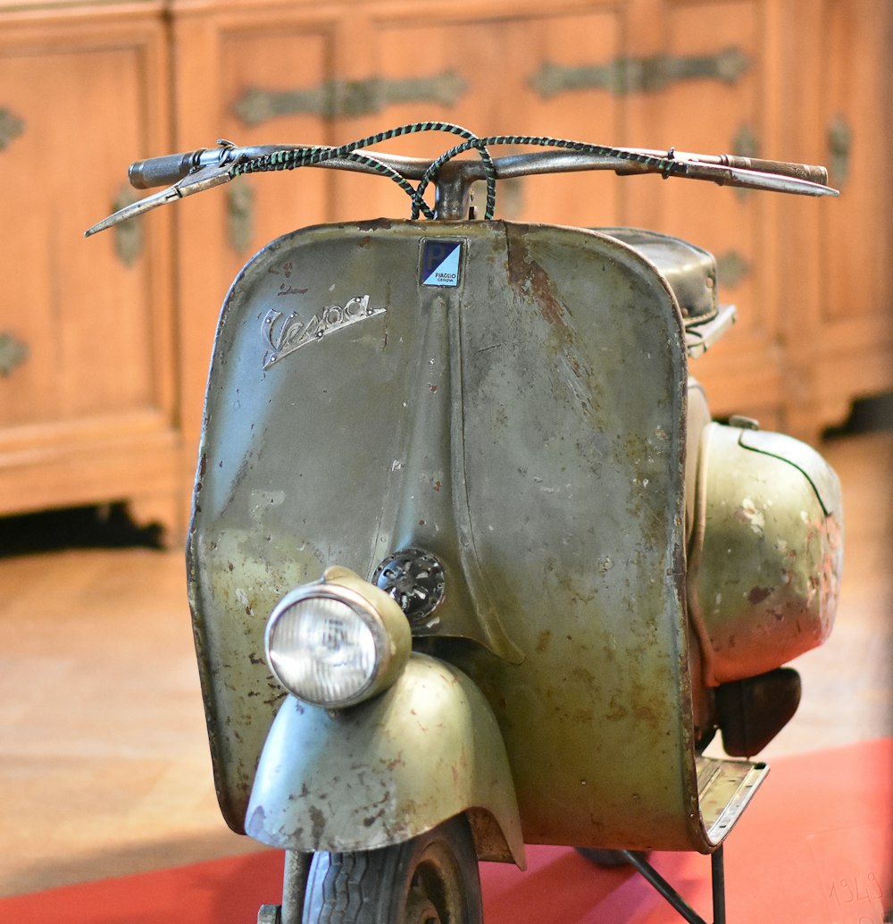 an old scooter is sitting on a red carpet