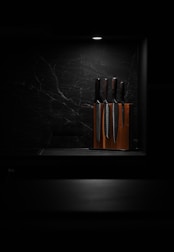A beautifully arranged chef knife set on a rustic wooden table.