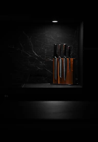 Close-up of sharp kitchen knives laid out on a wooden block with natural light.