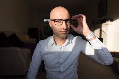 A friendly insurance adjuster reviewing damage photos with a homeowner in a sunlit living room.