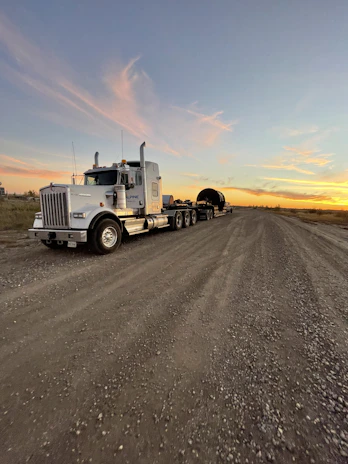 Modern low-chassis semi-trailer parked outdoors under clear sky