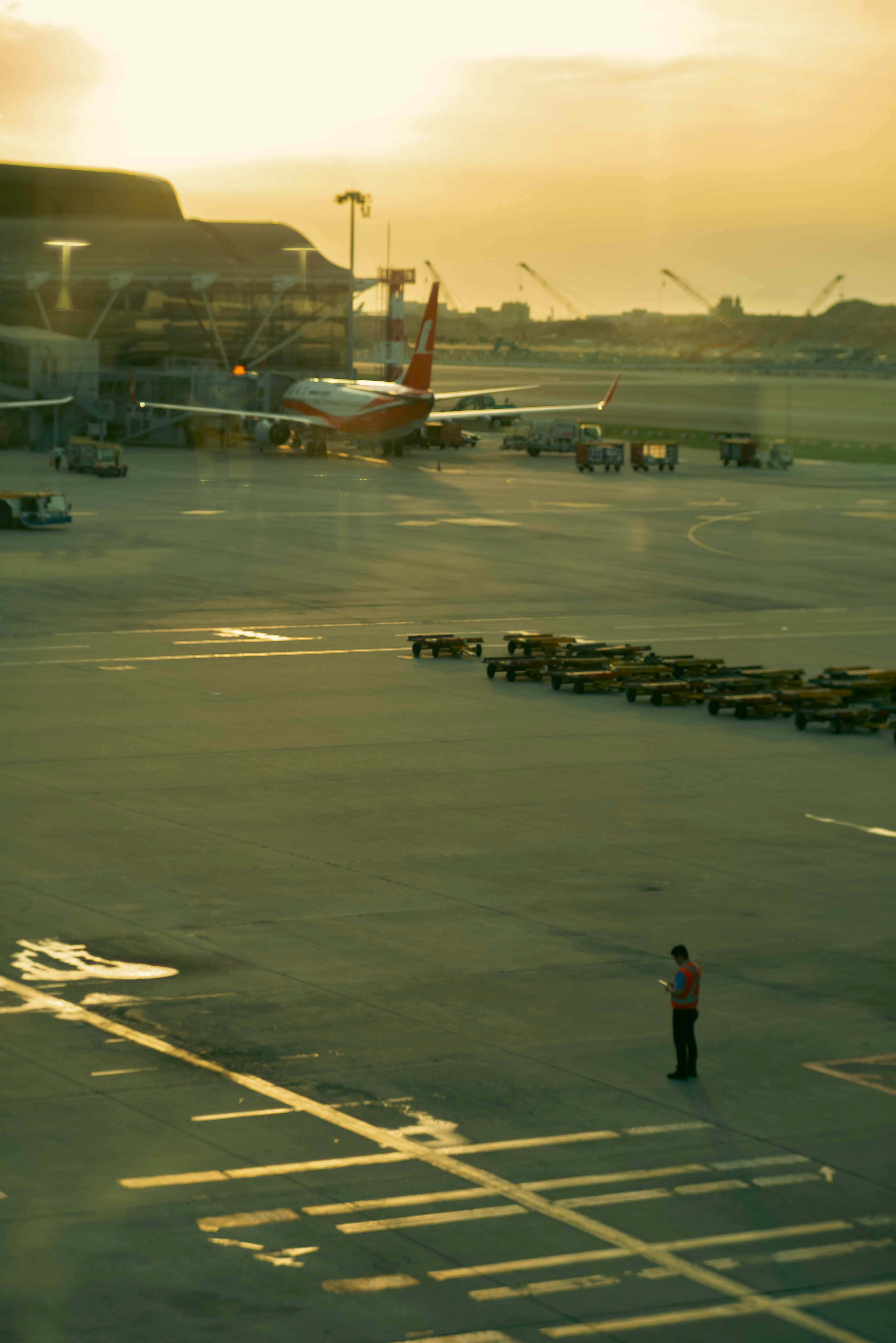 a man standing in a parking lot next to an airplane