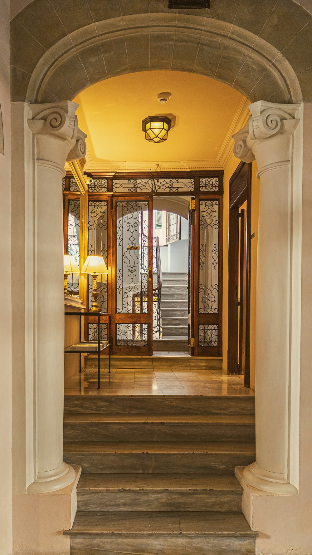 a hallway with a staircase and a lamp