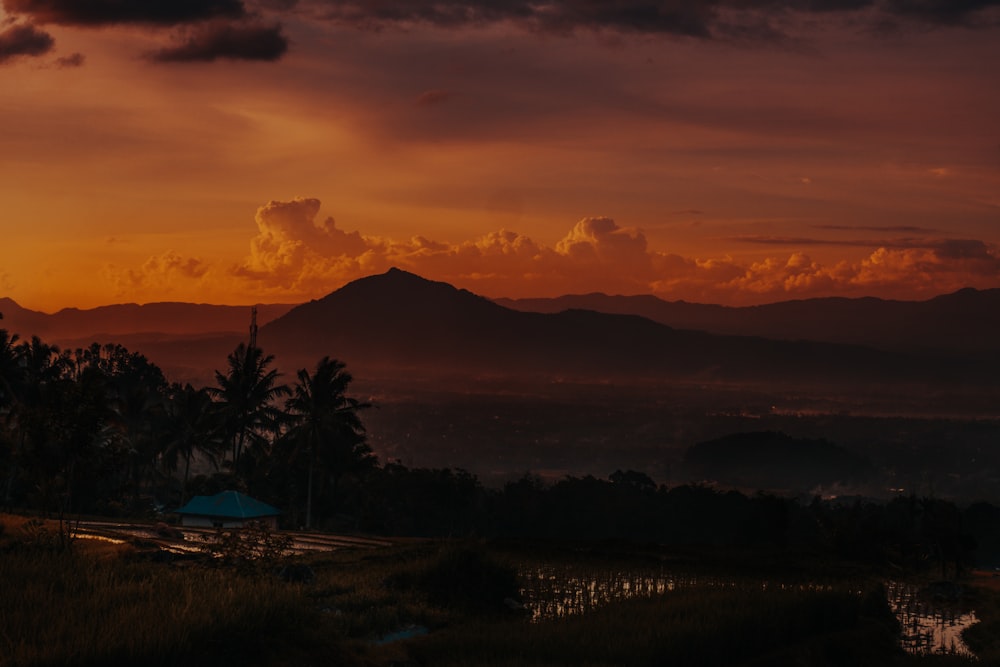 the sun is setting over a mountain range