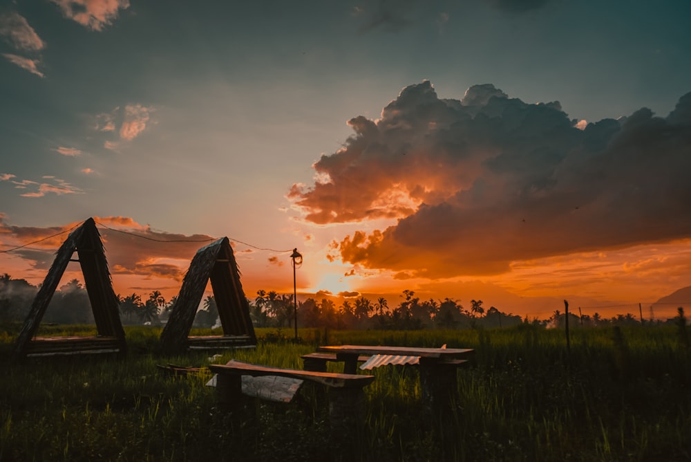 the sun is setting over a grassy field