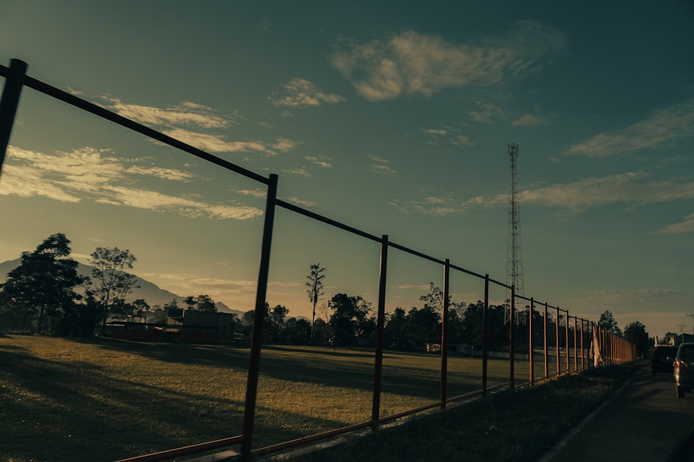 a person walking down a path next to a fence