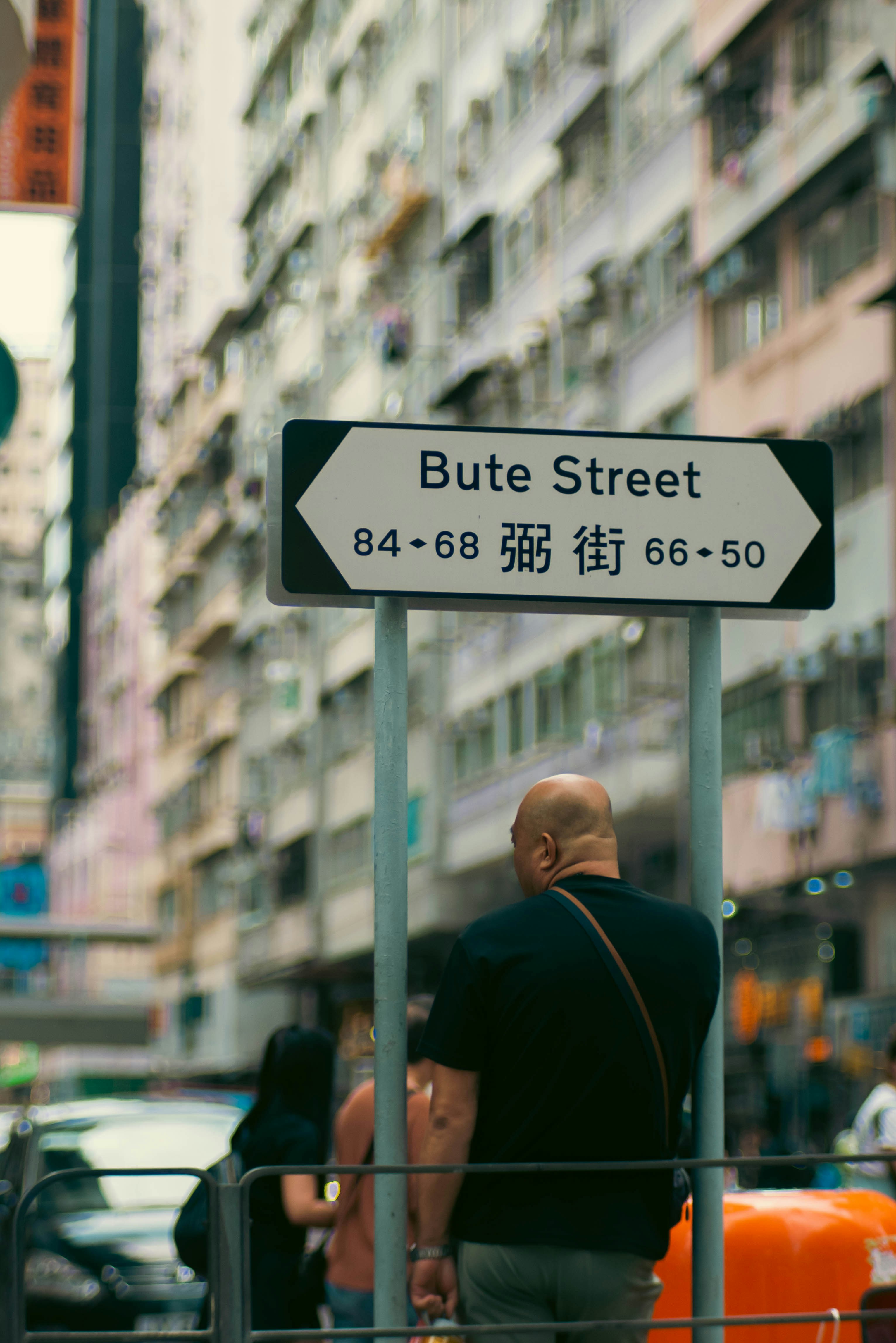 a man standing next to a street sign
