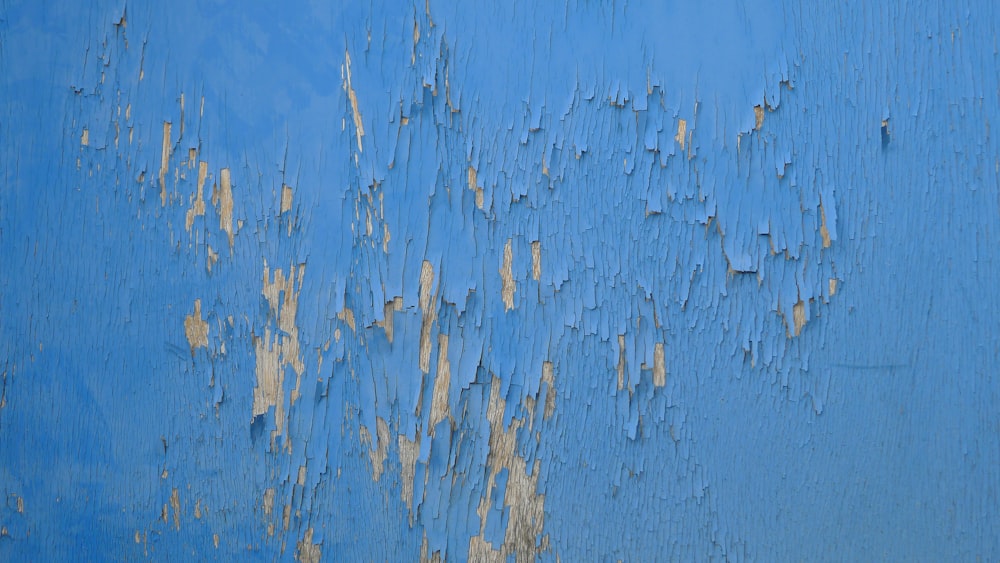 eine blaue Wand mit abblätternder Farbe darauf