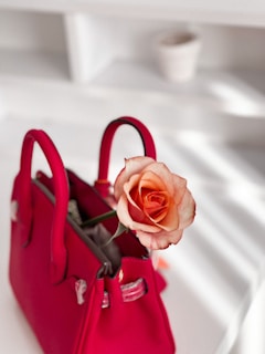 Close-up of delicate rose gold accents on a Lumina Apparel handbag resting on a marble surface.