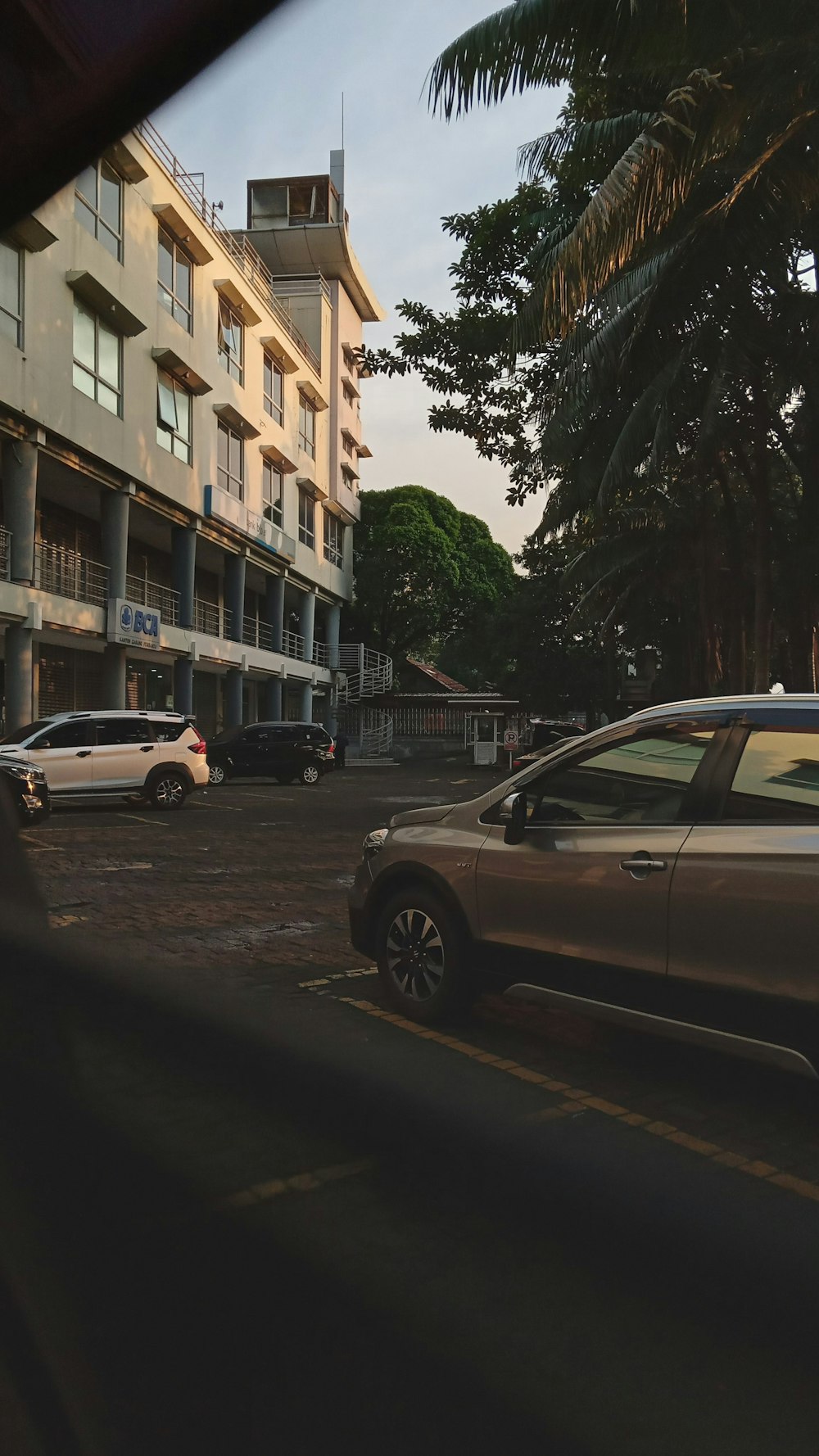 a car parked in a parking lot next to a tall building