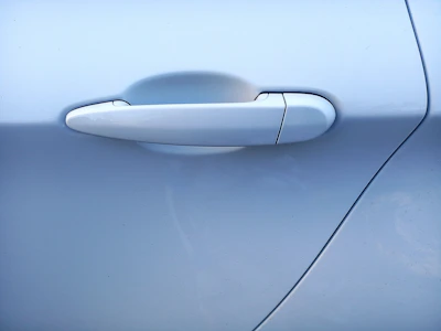 Close-up of sleek European car door handle with subtle electric blue accent lighting
