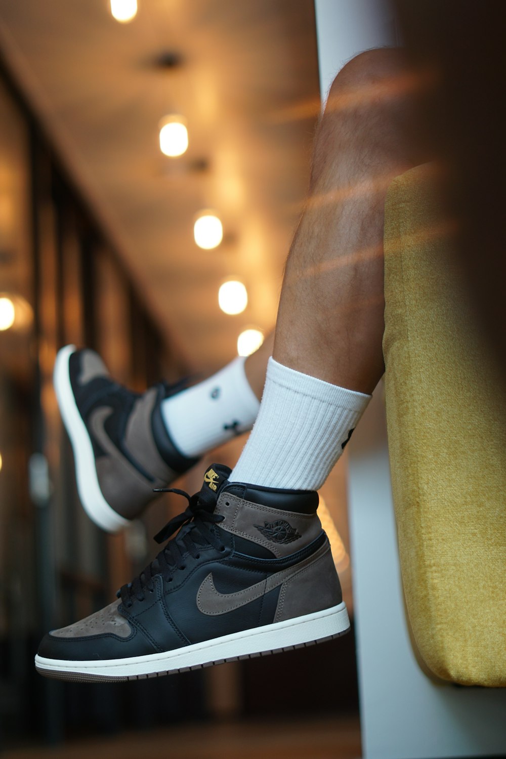a man's feet with white socks and nike sneakers