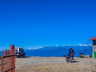 A breathtaking view of a mountain landscape with a motorcycle parked in the foreground.