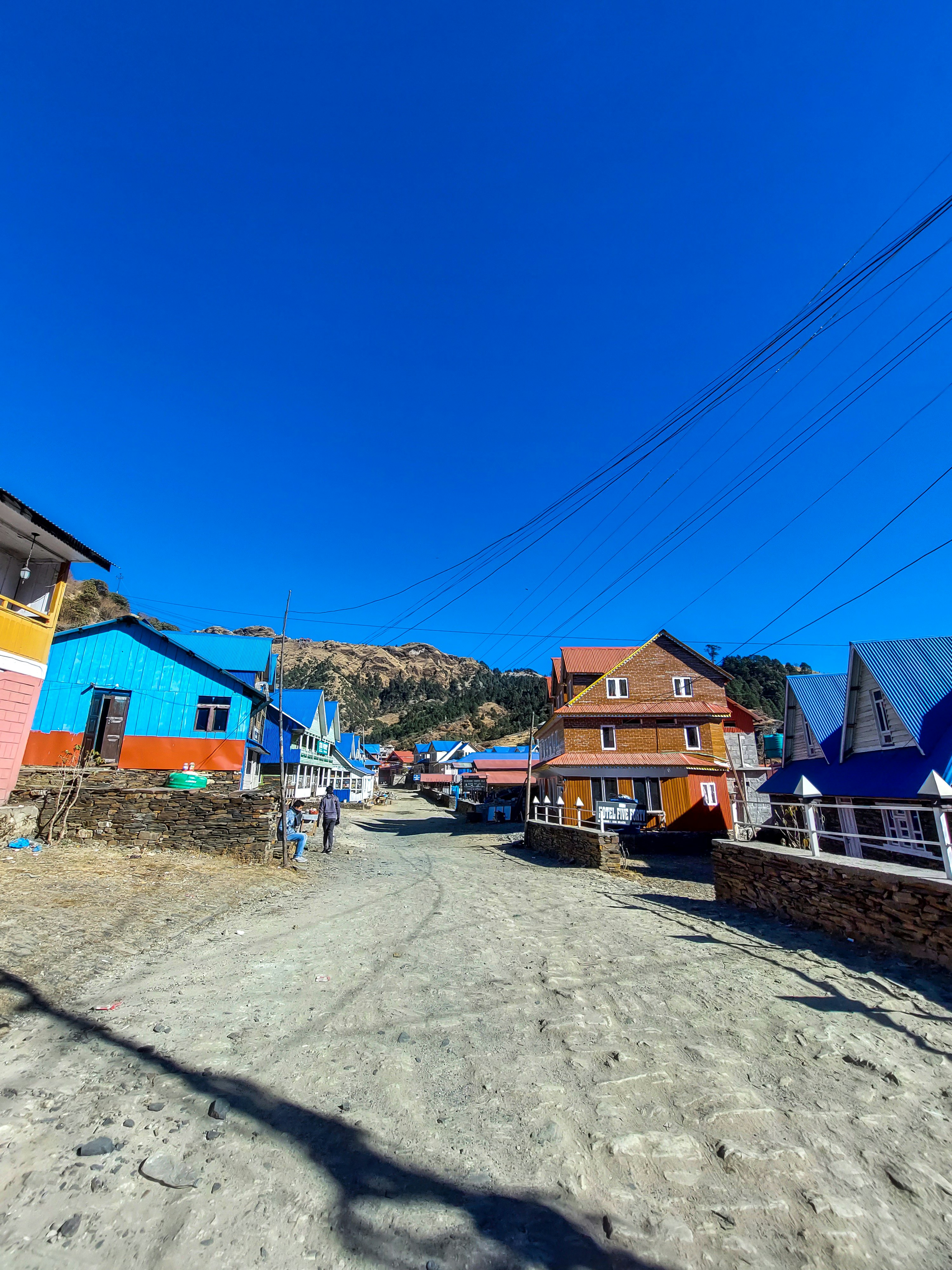 uma estrada de terra cercada por casas coloridas