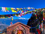 Bright prayer flags fluttering in the breeze against a clear blue sky at a sacred site