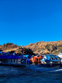 A vibrant local village scene with traditional music and colorful attire under a clear blue sky.