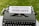 A vintage typewriter with a piece of paper in it, displaying the words 'Parenting Podcasts'. The typewriter is set on a grassy surface.