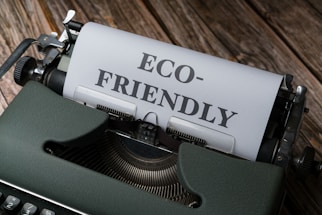 a close up of a typewriter with a paper that reads eco - friendly