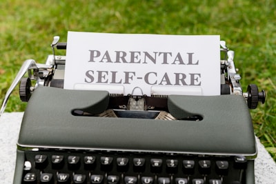 a typewriter with a paper that reads parental self - care