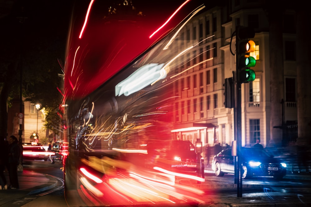 a double decker bus driving down a street at night