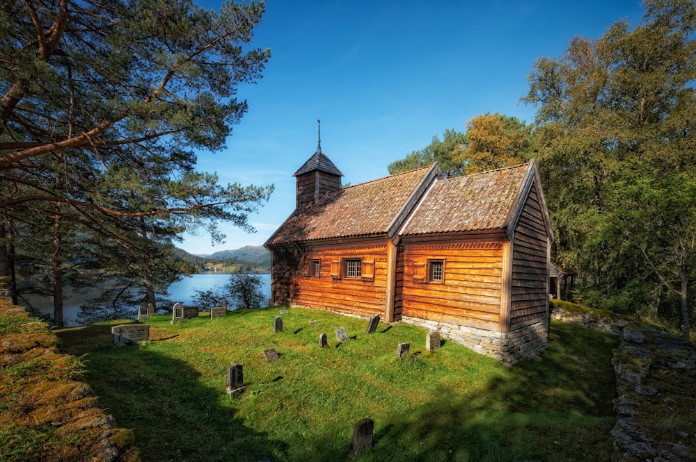 eine alte Holzkirche mit einem Kirchturm neben einem Gewässer