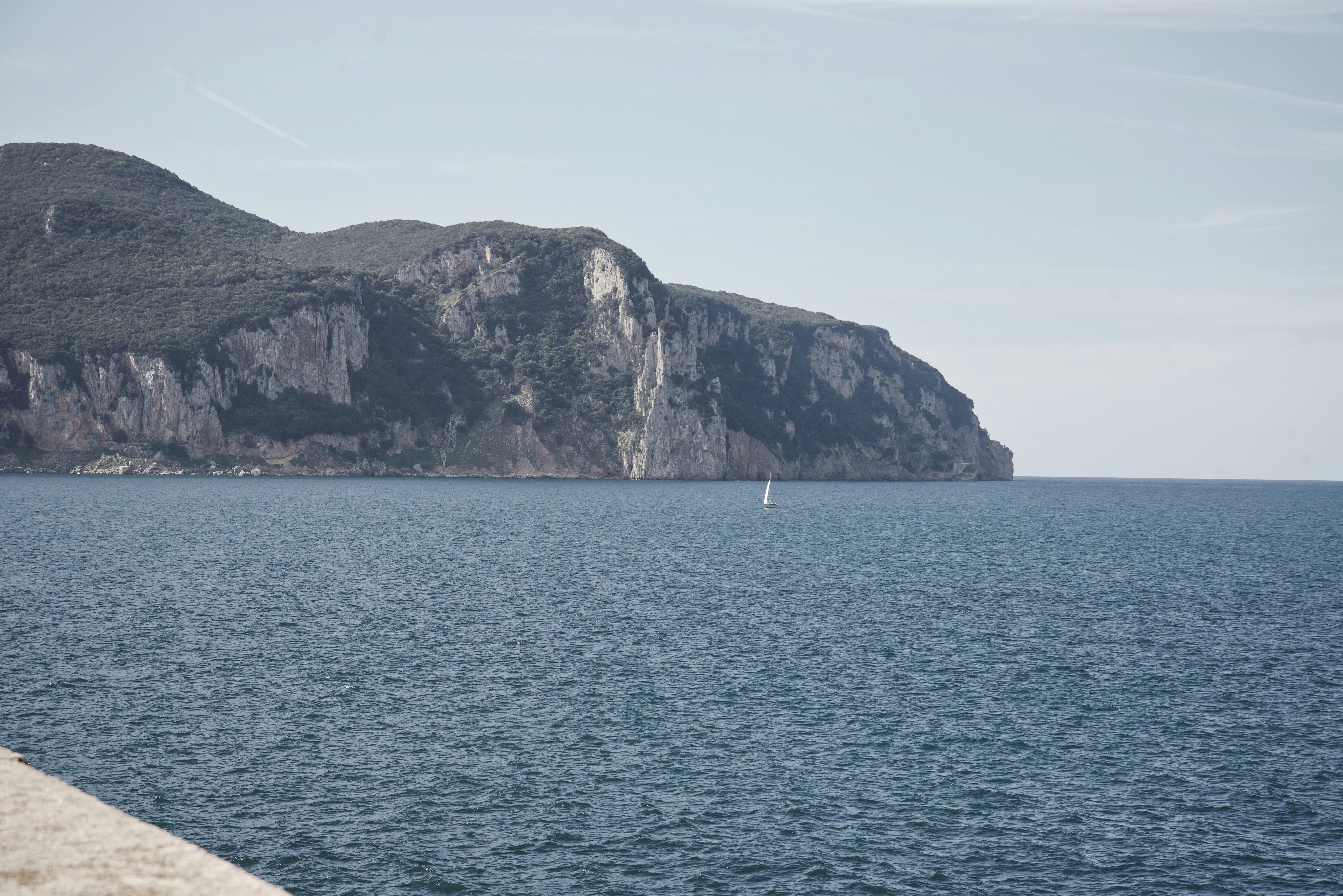 a lone sailboat in the middle of a large body of water