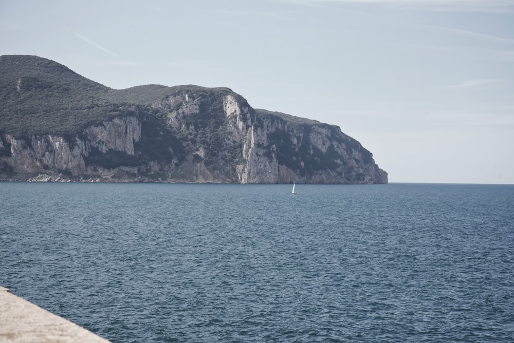 a lone sailboat in the middle of a large body of water