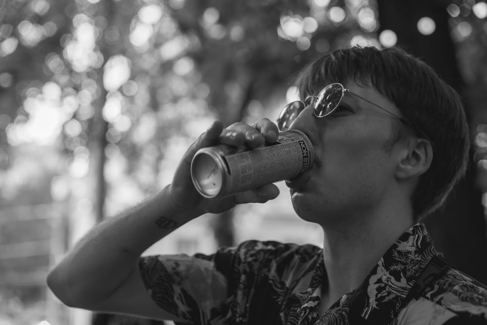 a man with glasses drinking from a cup