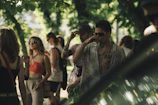 A laid-back gathering of friends wearing ísbírí pieces in a sunlit forest clearing.