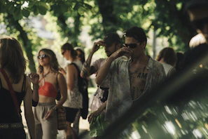 A laid-back gathering of friends wearing ísbírí pieces in a sunlit forest clearing.