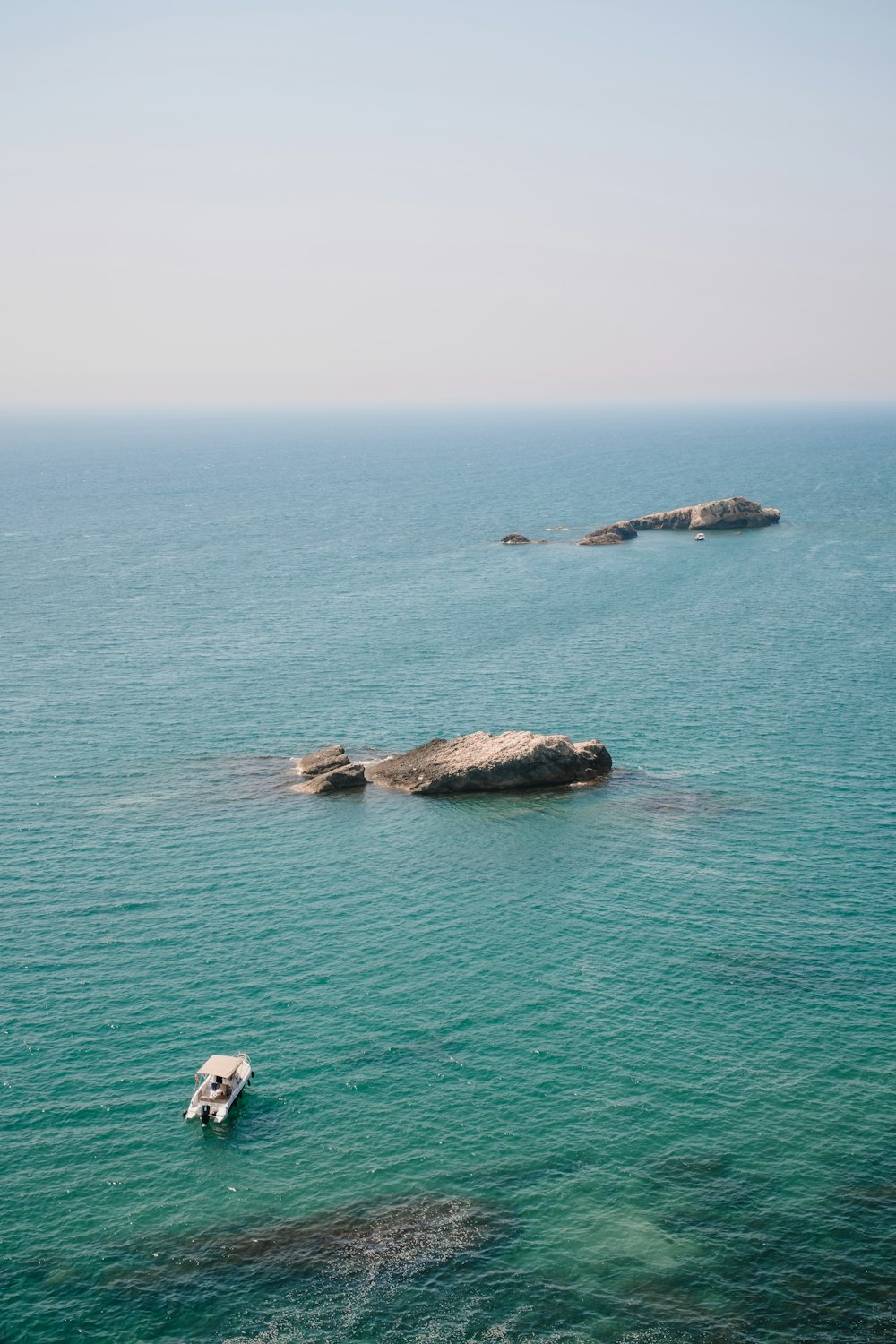 a small boat floating on top of a large body of water