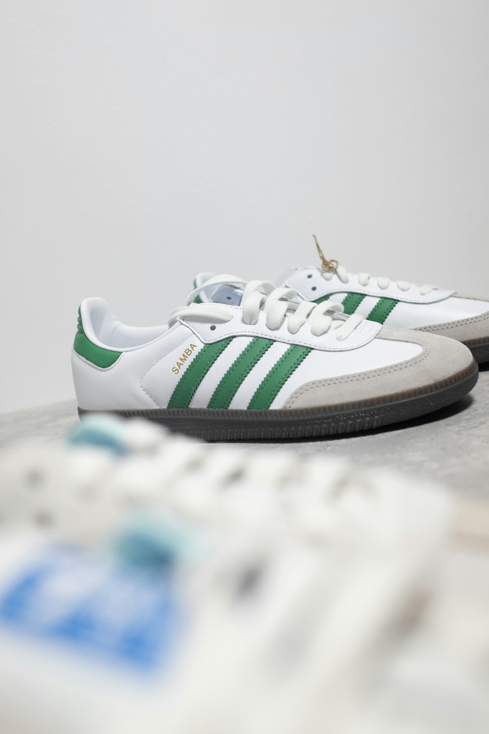 a pair of white and green adidas sneakers