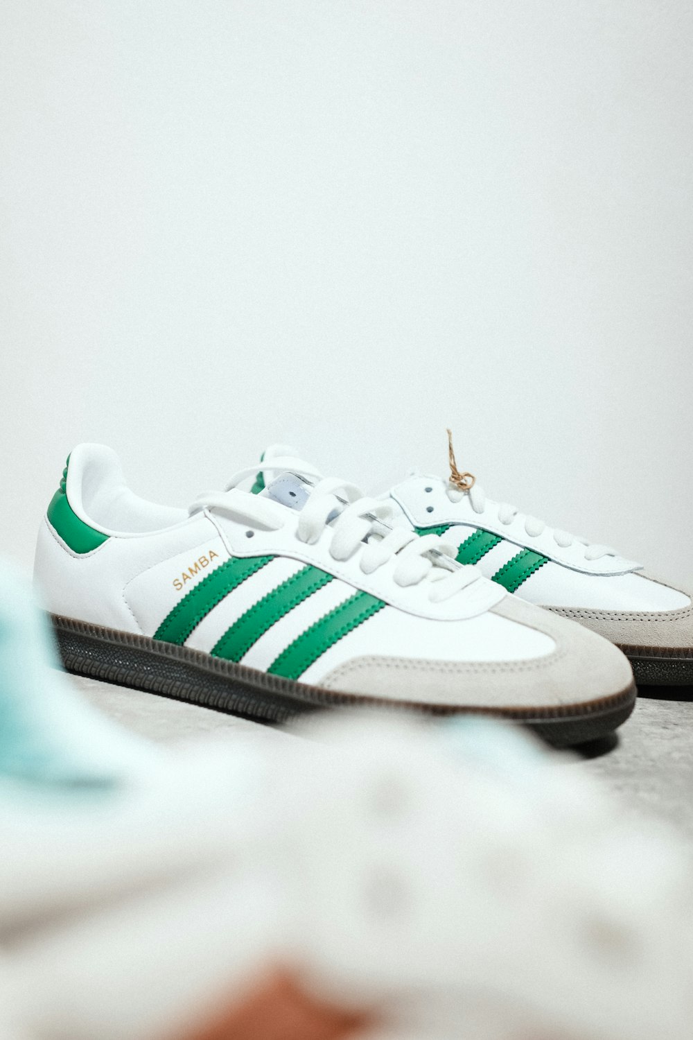 a pair of white and green adidas sneakers