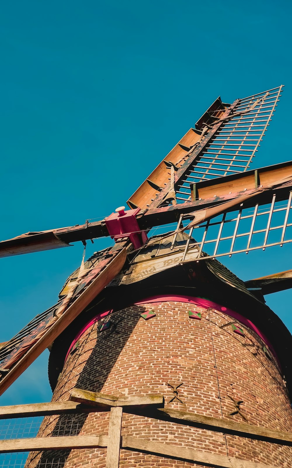 a windmill with a metal fence on top of it