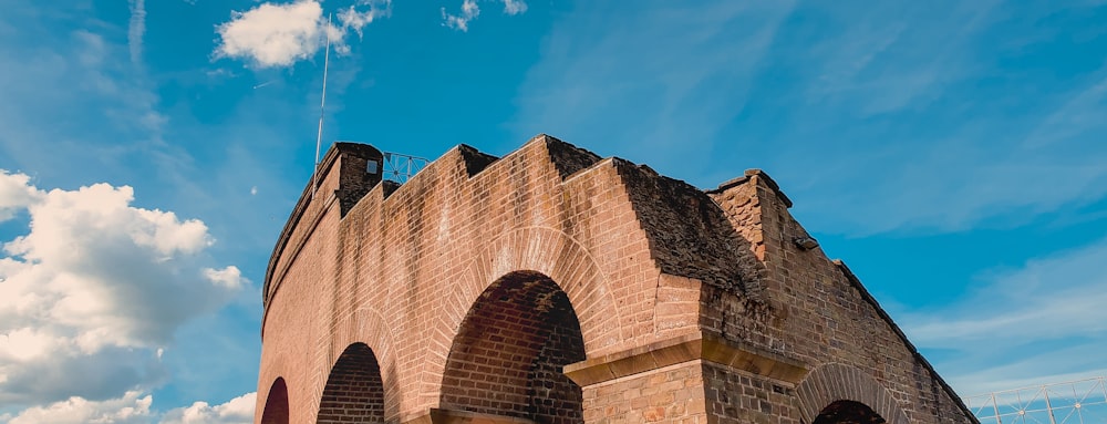 a tall brick building with arched windows under a blue sky